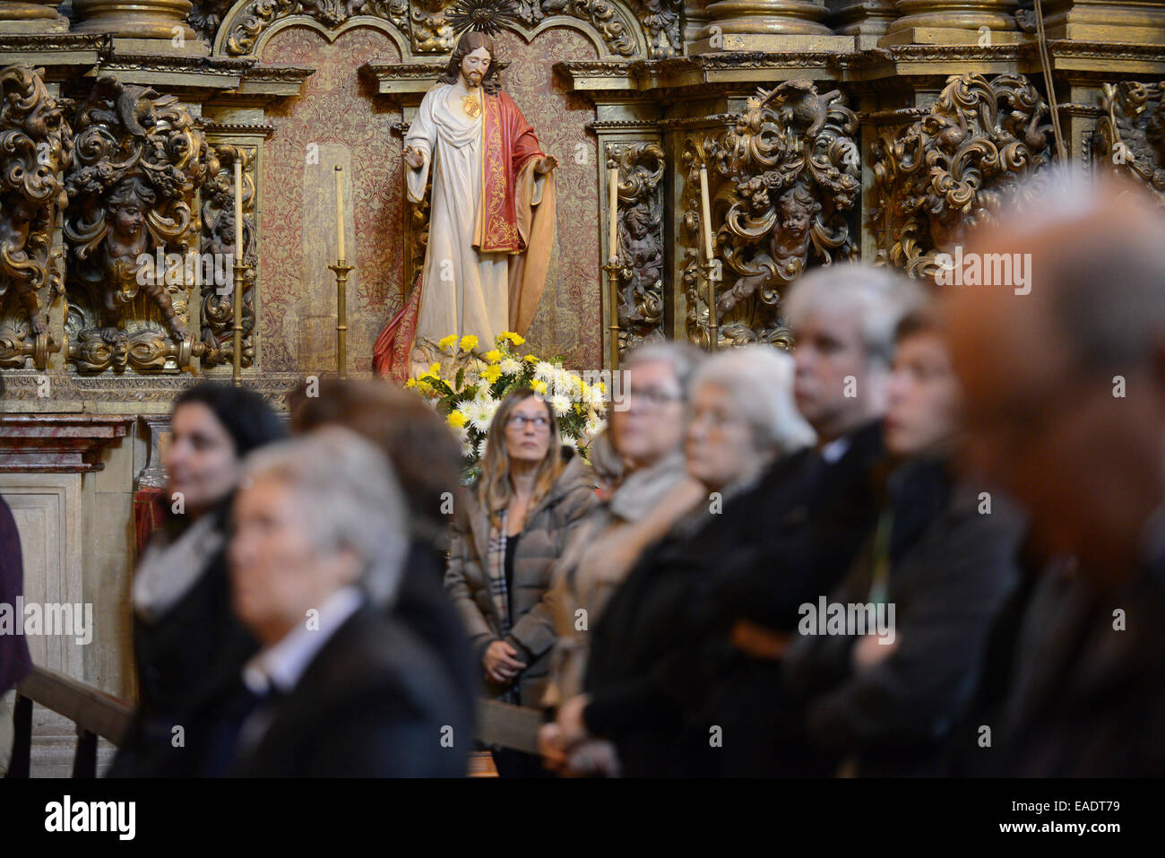 Statue of Jesus Christ above people during a catholic mass Stock Photo