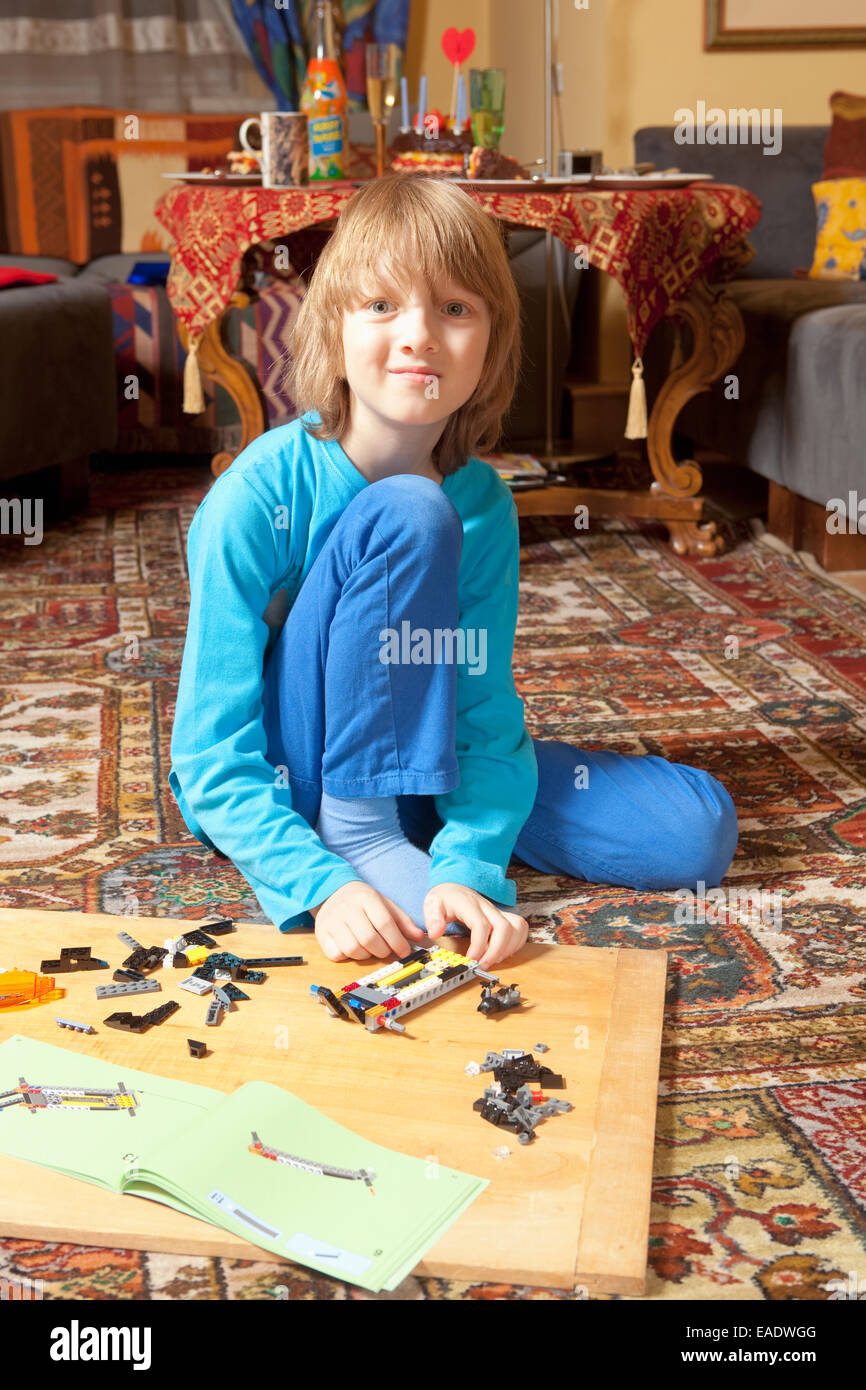 Boy Putting Together his Assembling Toys on the Floor Stock Photo