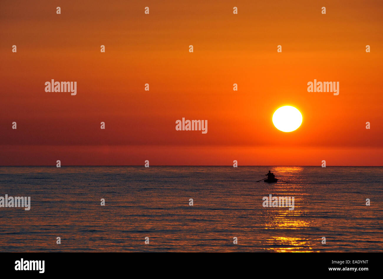 Silhouette of small boat against beautiful sunset Stock Photo - Alamy