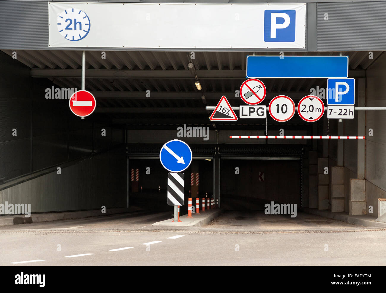 Entrance to the underground parking lot with multiple warning road signs Stock Photo