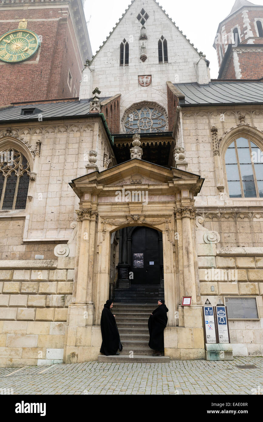KRAKOW, POLAND - OCTOBER 26, 2014: Two men wearing black cloaks guard the door of  the Basilica of St Stanislaw and Vaclav or Wa Stock Photo