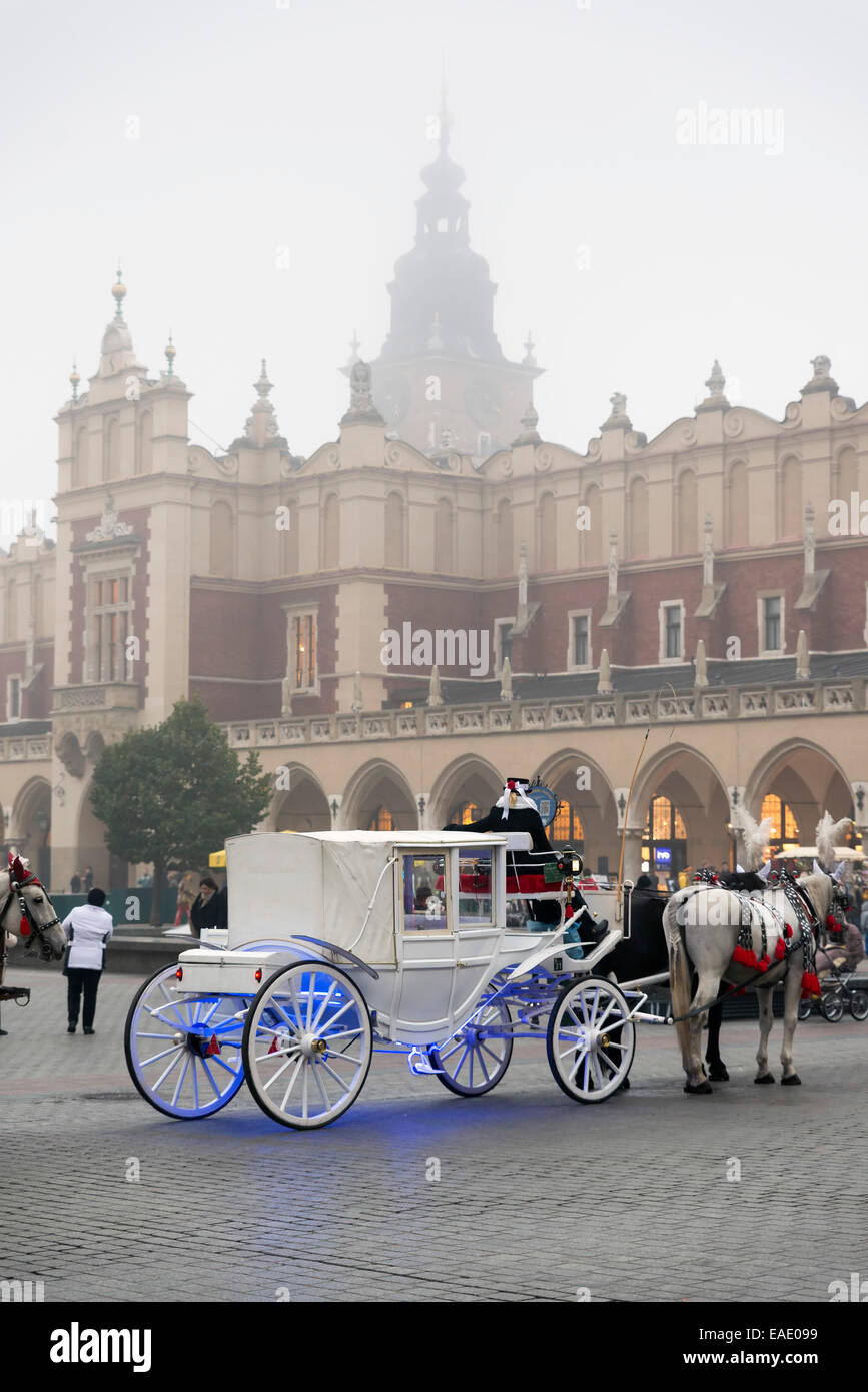 KRAKOW, POLAND - OCTOBER 26, 2014: Horse carriage on Krakow's Main Market Square. In the background is a historic town hall call Stock Photo