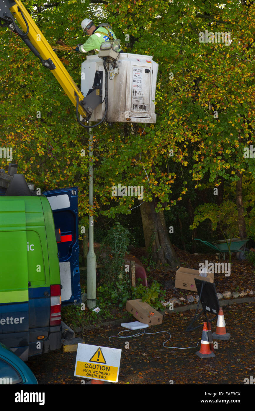 An engineer removes on old style street light and installs a low energy