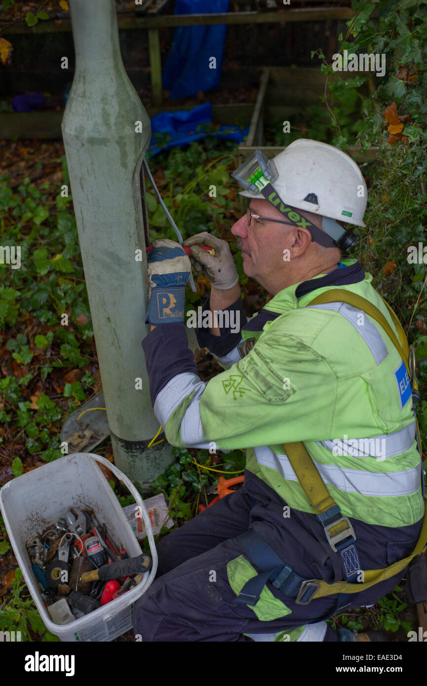 An engineer removes on old style street light and installs a low energy