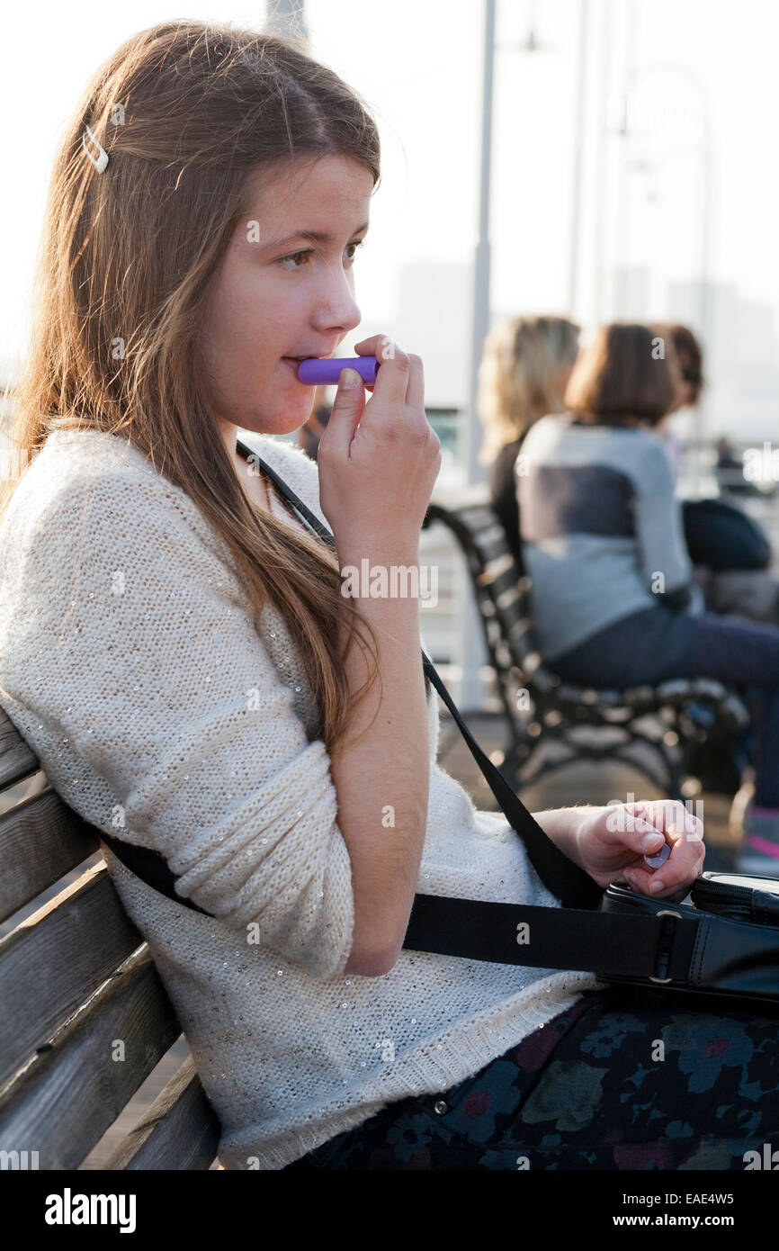 Girl Applying Lip gloss Stock Photo