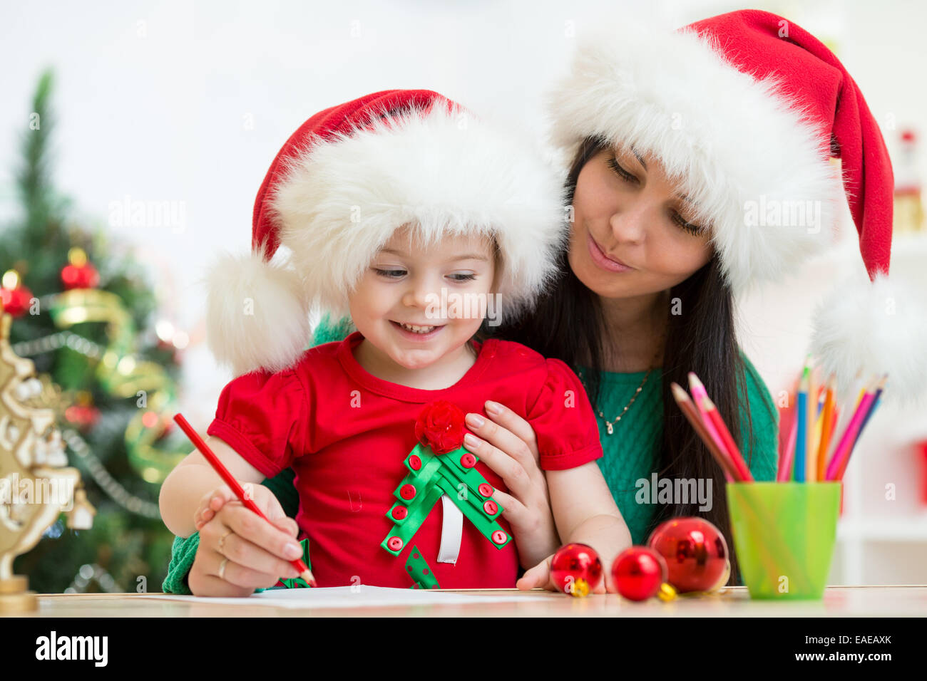 kid girl and mother writing letter to Santa Stock Photo