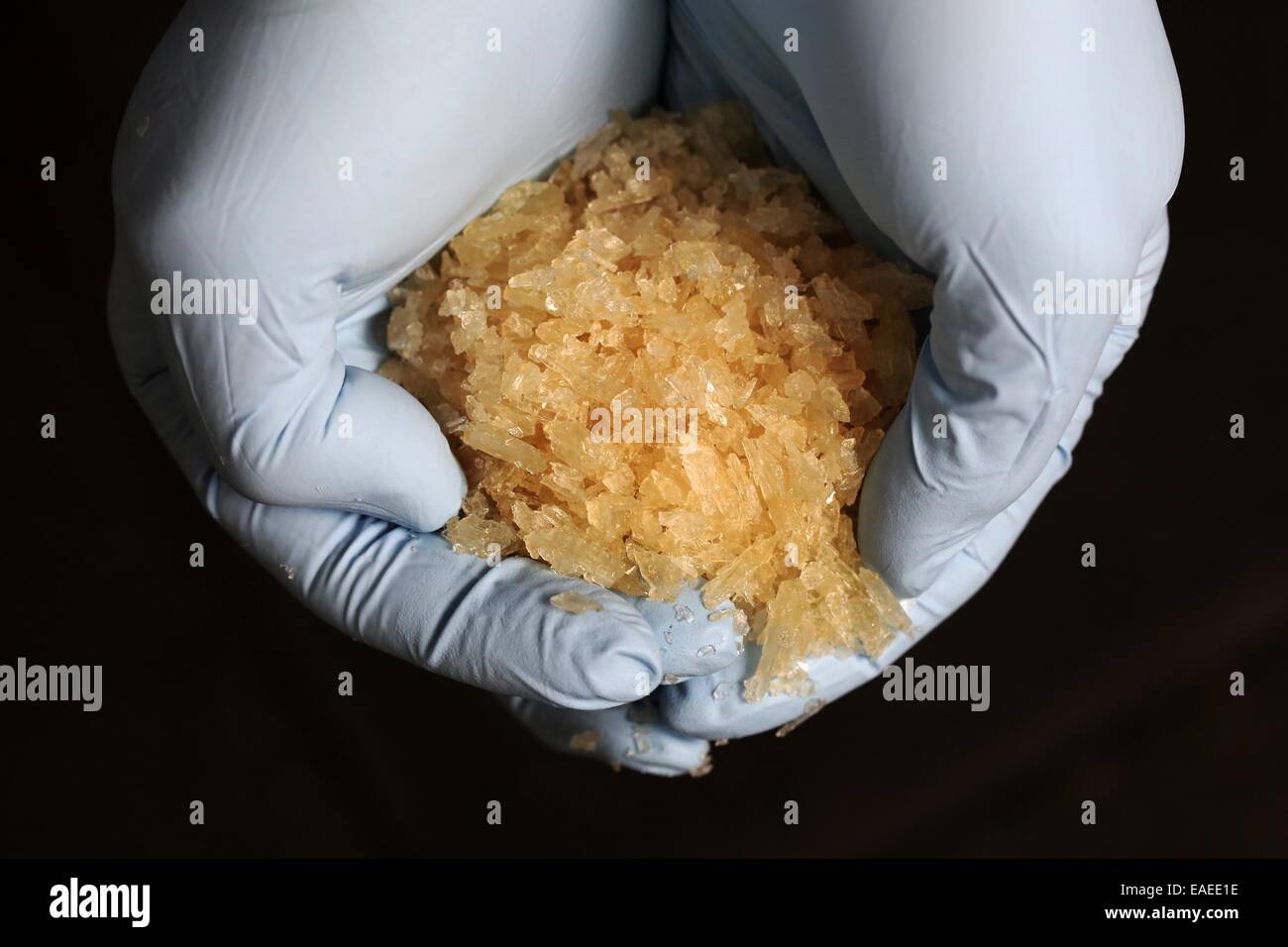 Wiesbaden, Germany. 13th Nov, 2014. An investigator of the Criminal Police Office (BKA) holds the drug Crystal Meth in his hands during a press conference in Wiesbaden, Germany, 13 November 2014. German and Czech investigators smashed a drug smuggling ring and ensured 2, 9 tons of a precursor to produce Crystel Meth. According to the BKA around 2, 3 tons of Crystal could have been produced with an assumed street value of 184 million euros. Photo: Fredrik von Erichsen/dpa/Alamy Live News Stock Photo