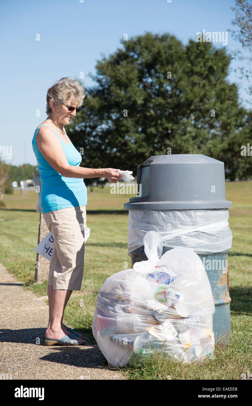 Woman using a rubbish bin to dispose of her garbage Stock Photo Alamy