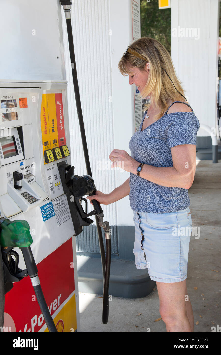 Woman motorist at a gas station in USA selecting grade of petrol Stock