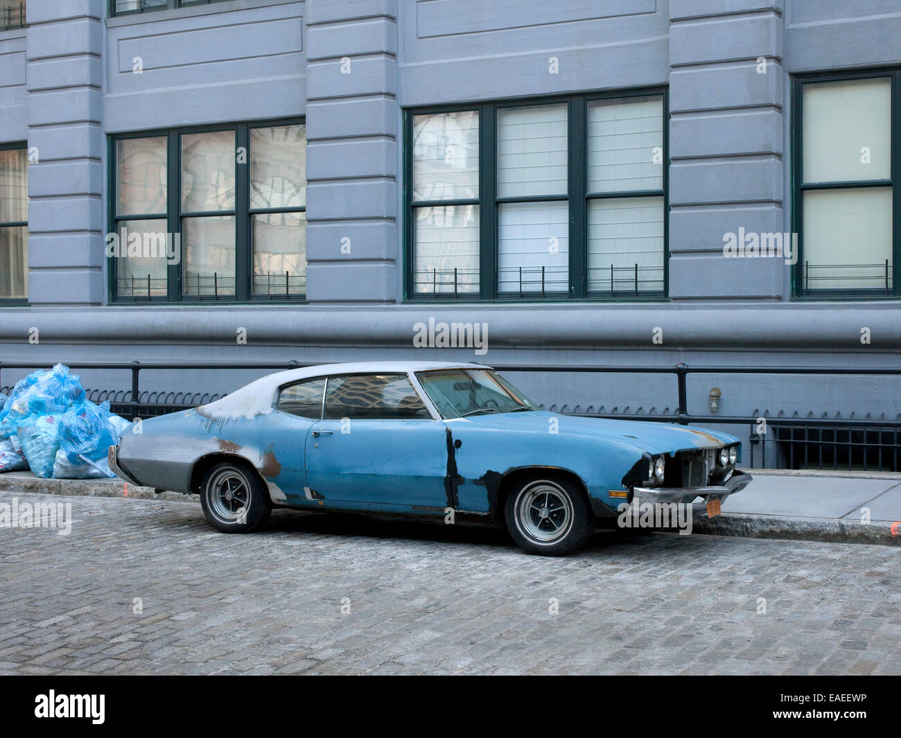 powder blue seventies muscle car on cobblestone street in city Stock Photo