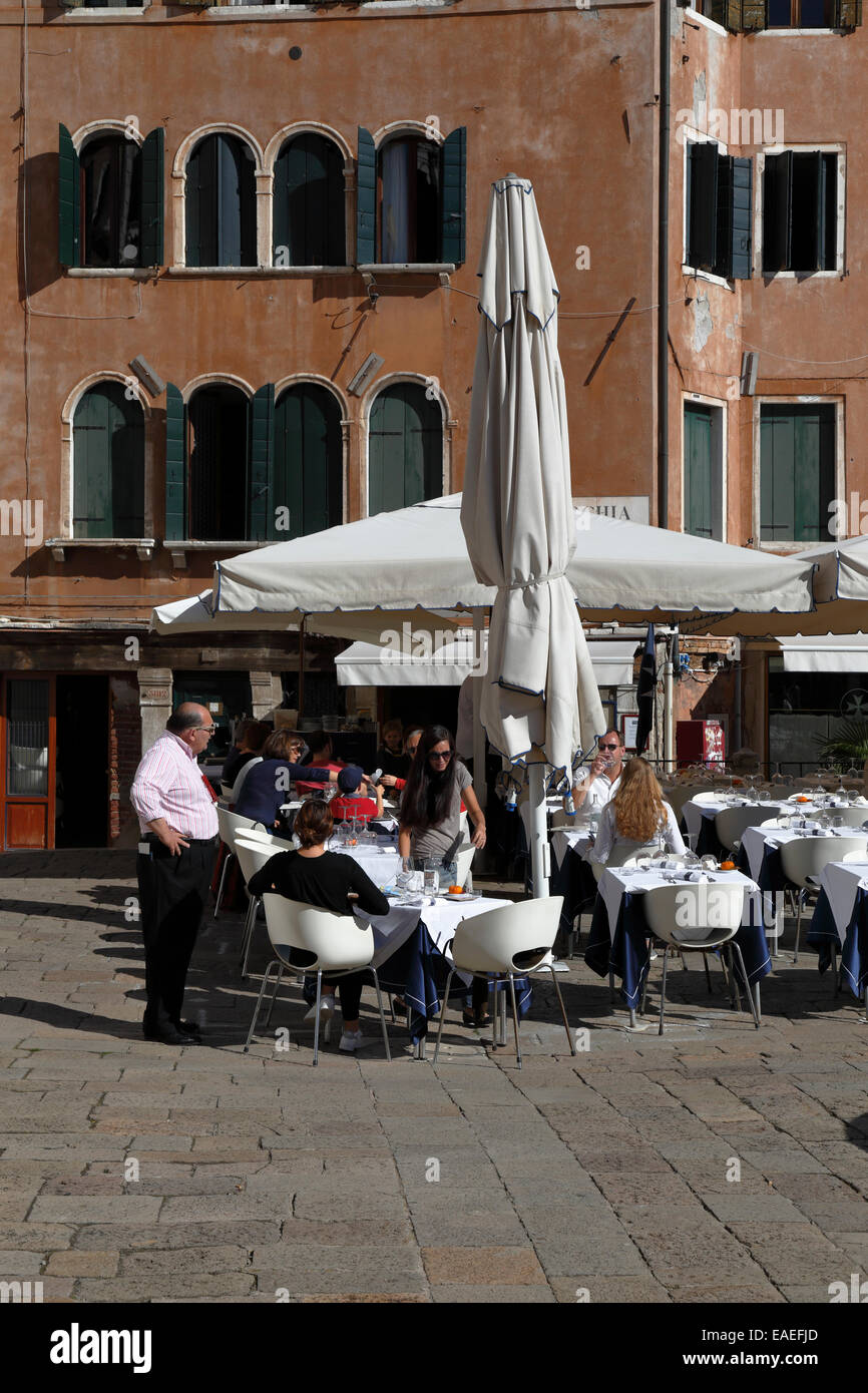 Diners outside a restaurant in Campo Santo Stefano, Venice, Italy. Stock Photo