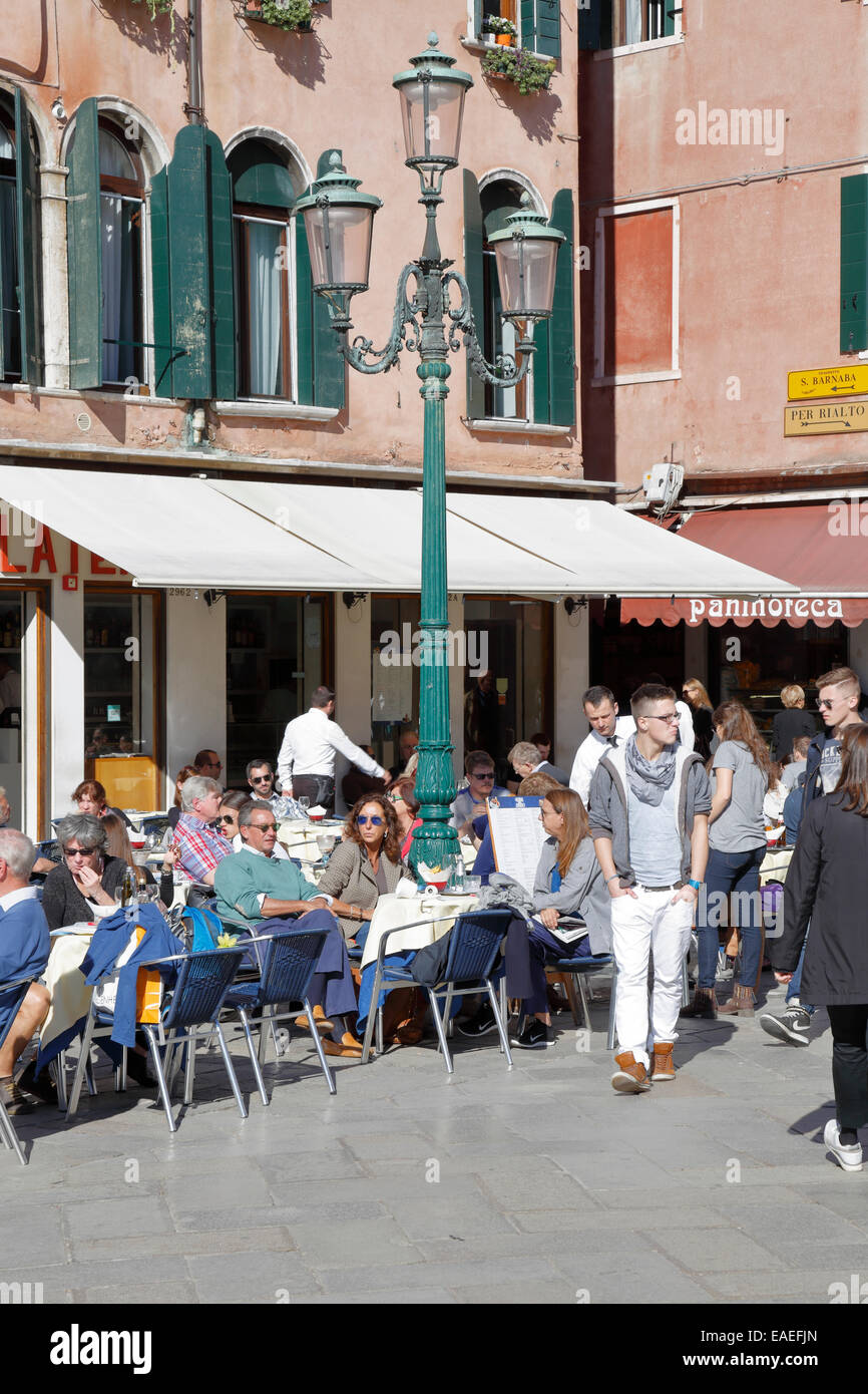 Diners outside a restaurant in Campo Santo Stefano, Venice, Italy. Stock Photo