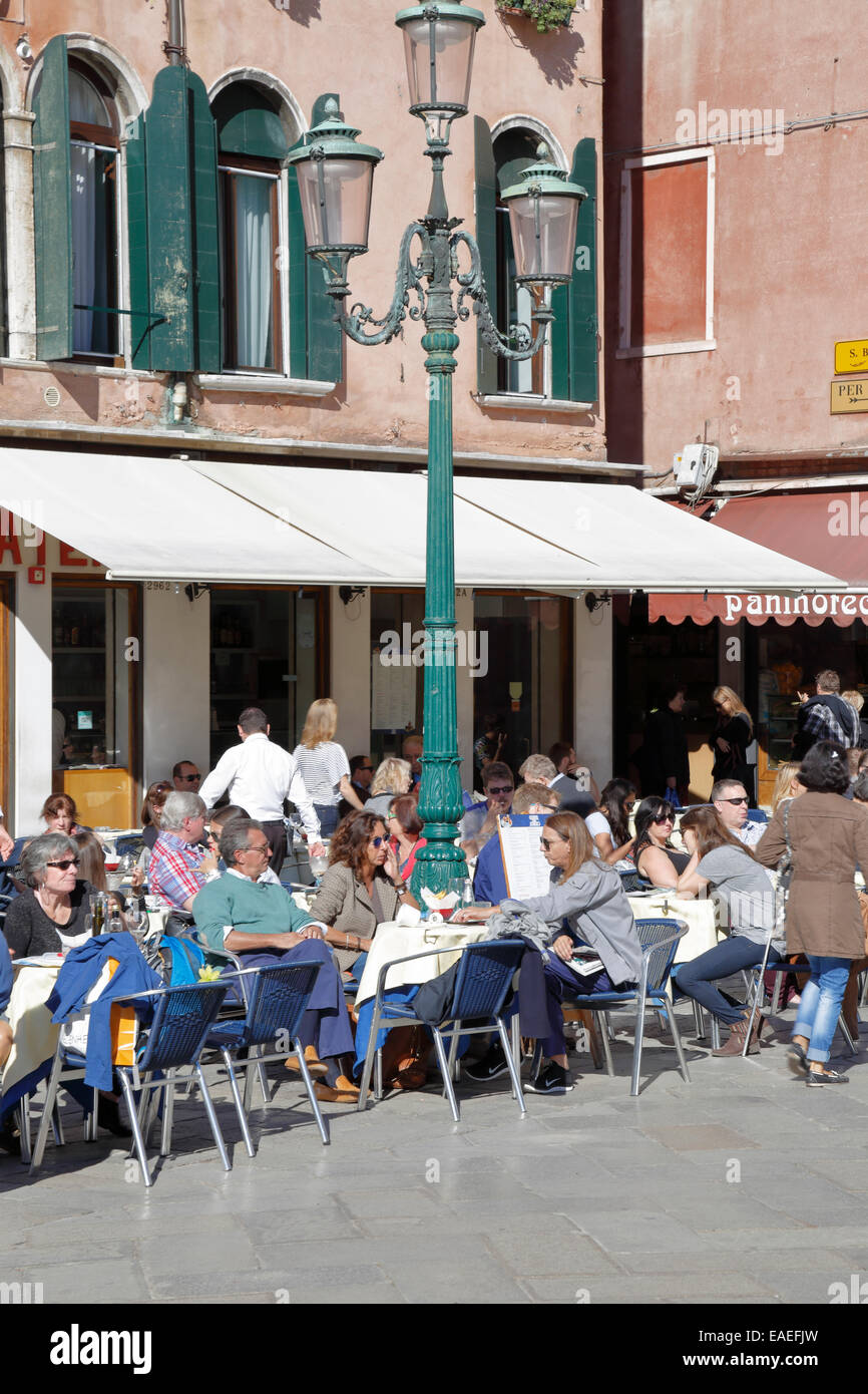 Diners outside a restaurant in Campo Santo Stefano, Venice, Italy. Stock Photo