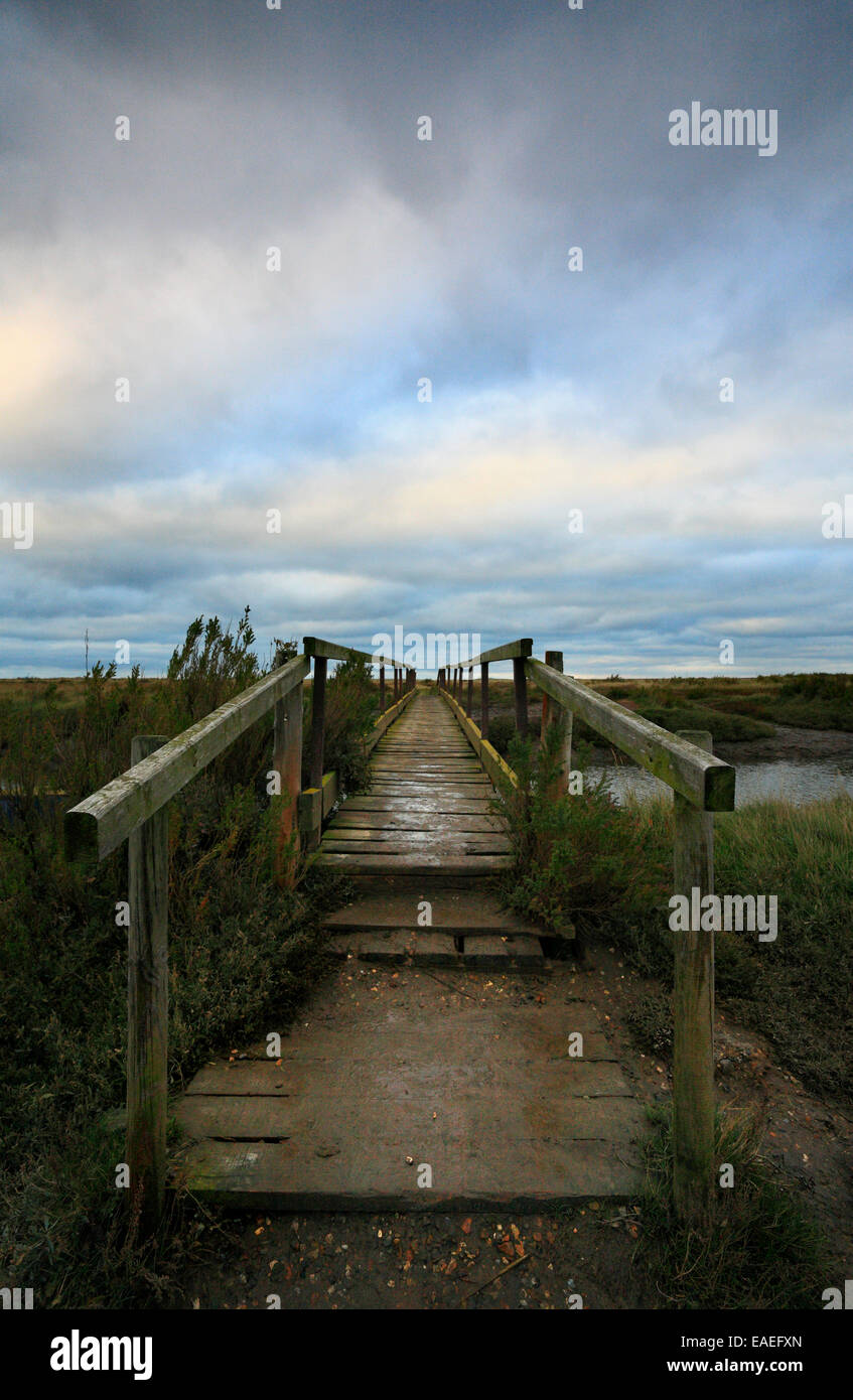 Wooden bridge over a creek in the marshes at Morston on the North Norfolk coast. Stock Photo