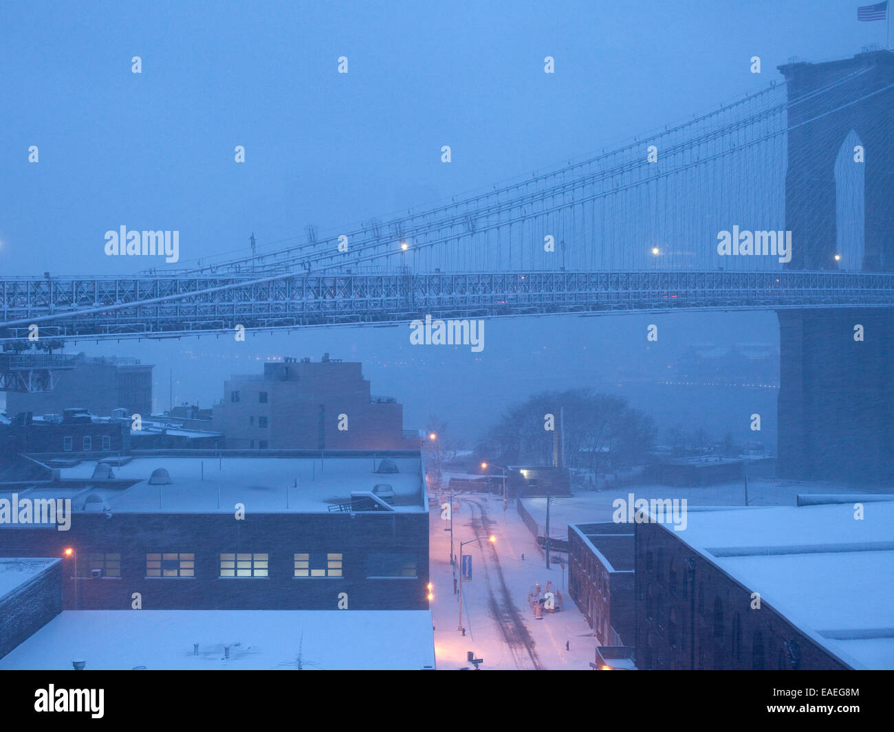 span of Brooklyn Bridge at dusk with fog and snow Stock Photo