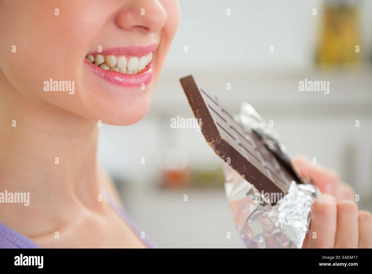 Closeup on happy young woman eating chocolate Stock Photo