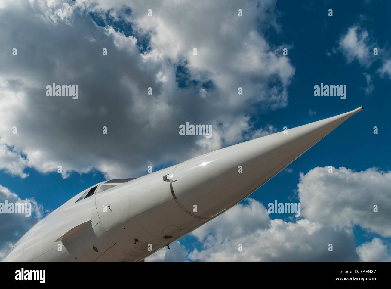 The nose of a supersonic airliner, Concorde, against a blue sky with white clouds Stock Photo