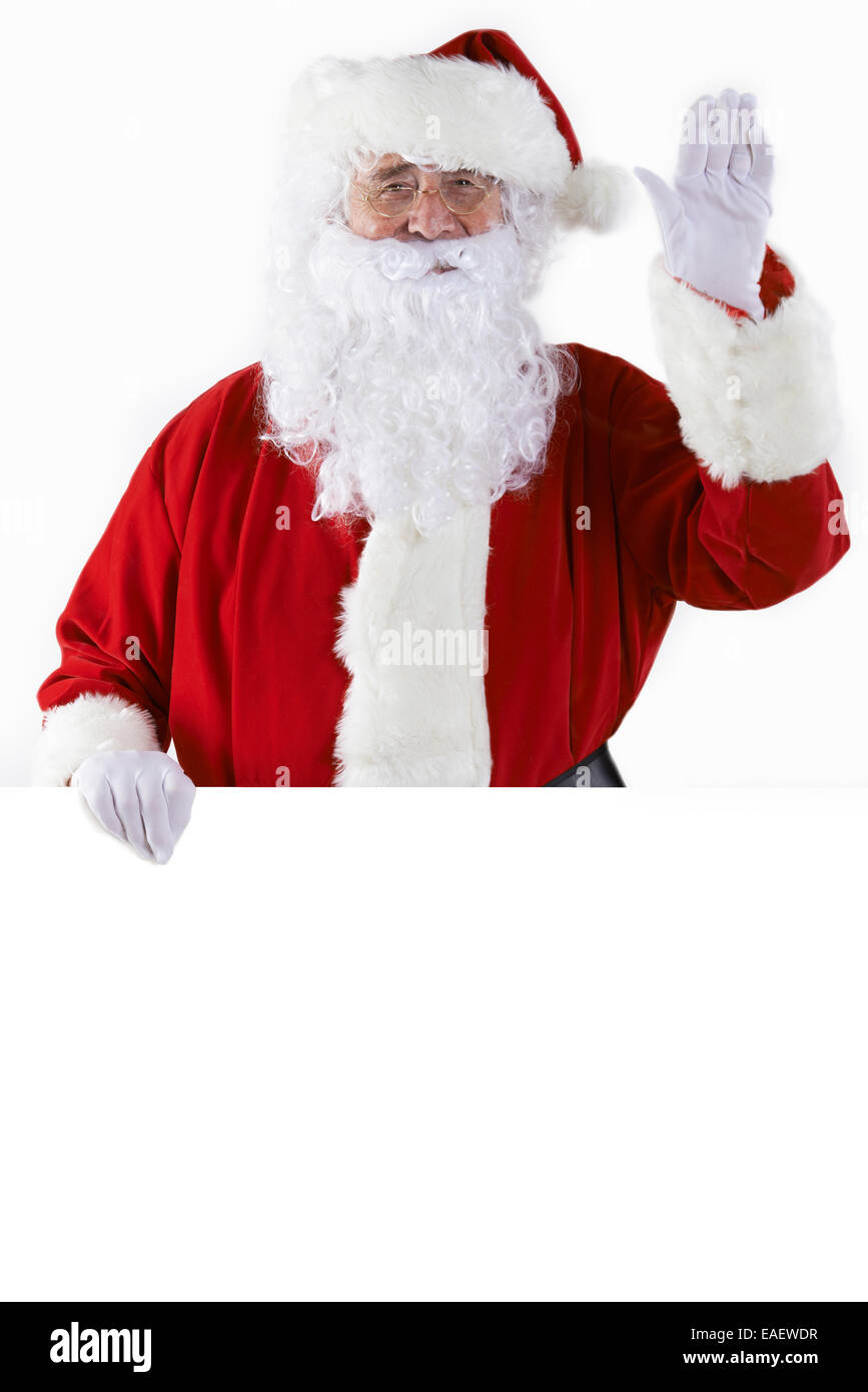 Studio Shot Of Santa Holding Blank Piece Of White Card And Waving Stock ...