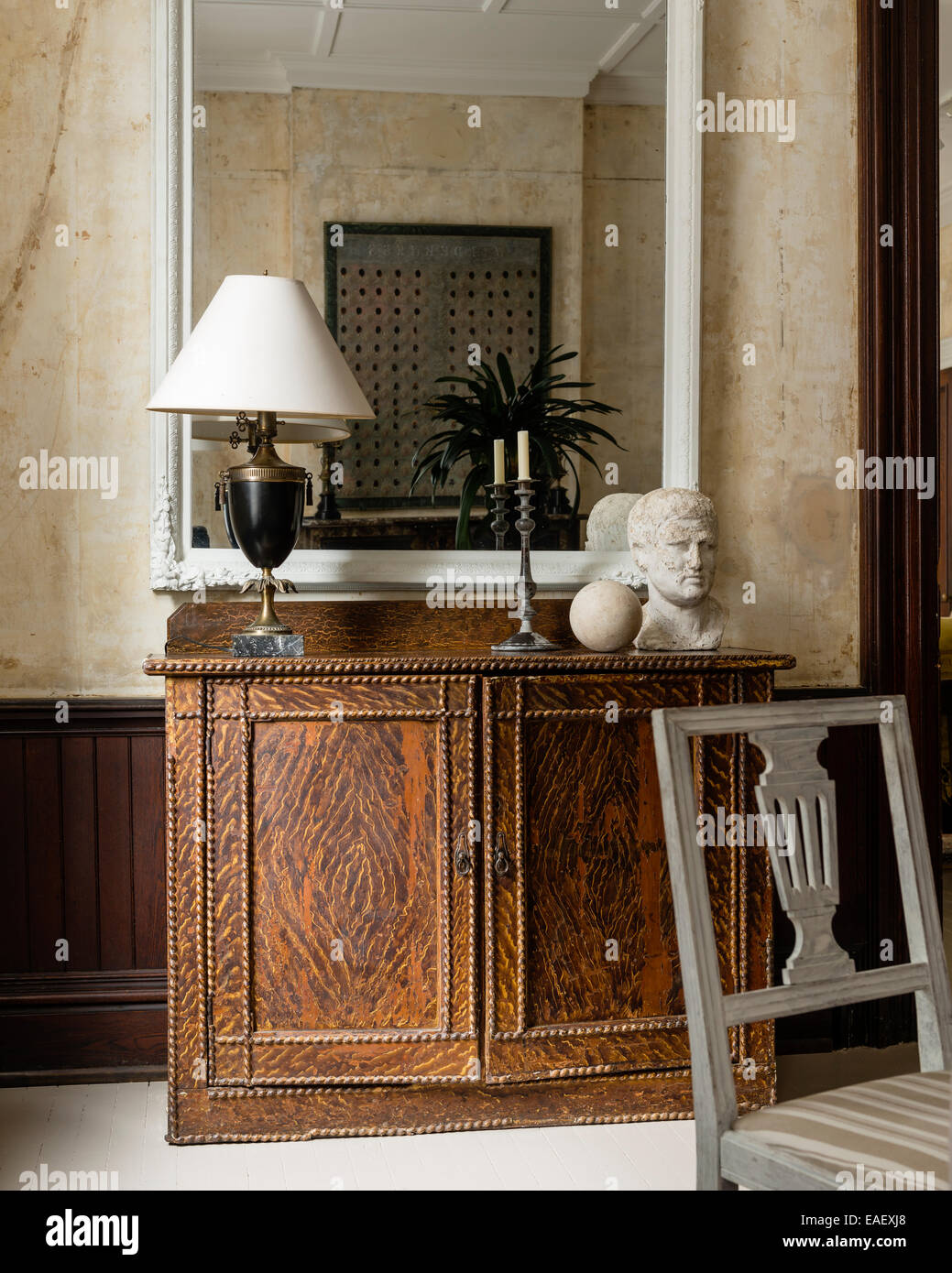 Large mirror above 19th century 'grained' cupboard Stock Photo