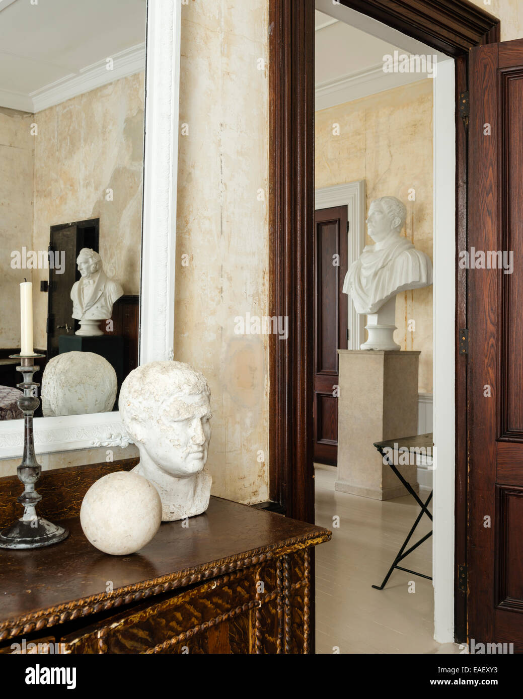 View through open doorway to large plaster bust on plinth Stock Photo