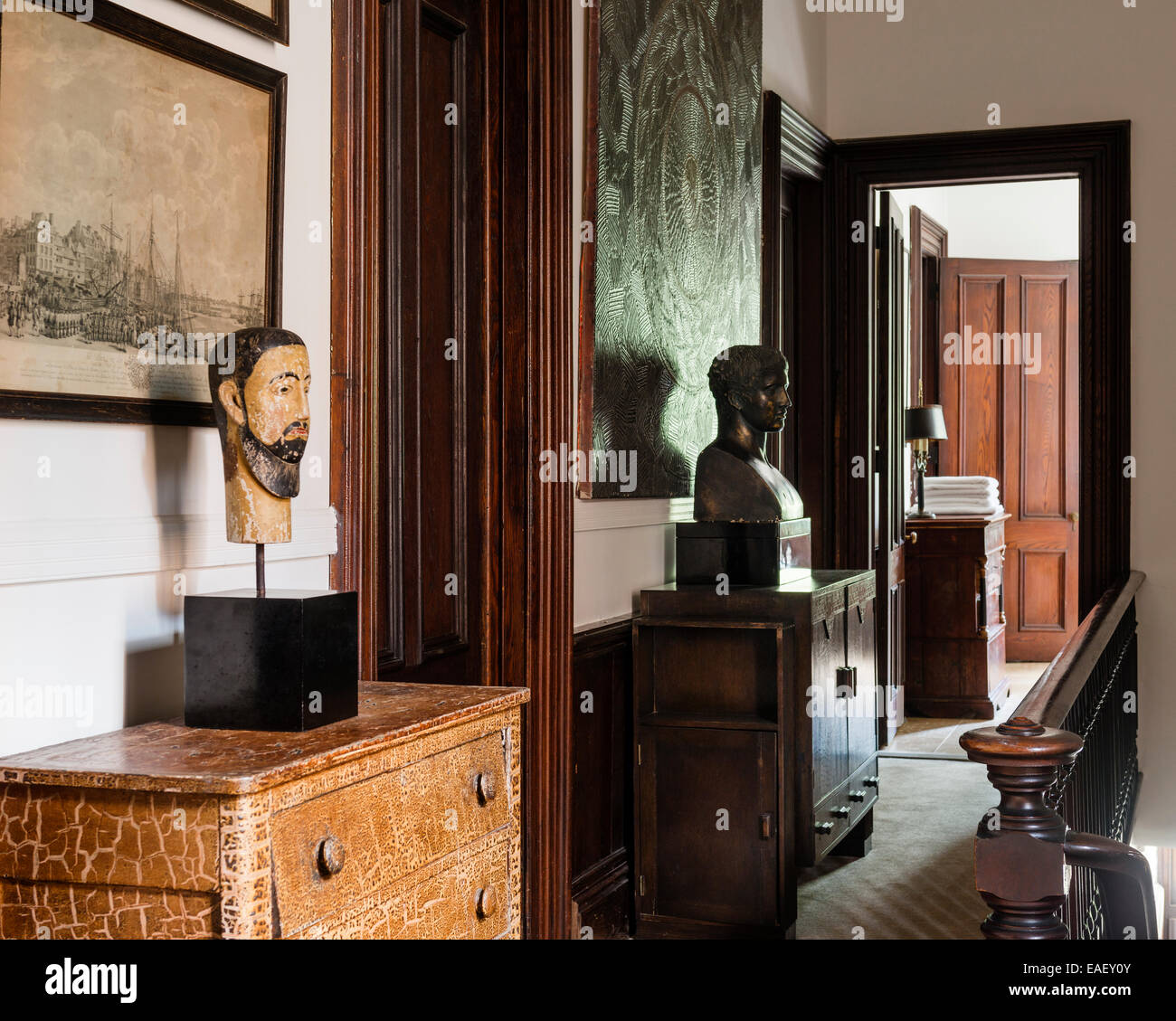 Landing furnished with chests and portrait busts. The bust on the