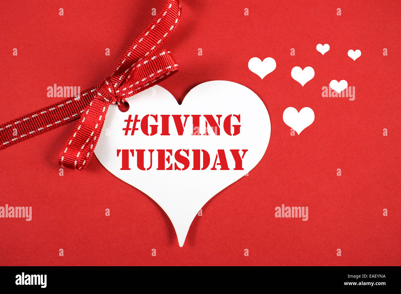 Giving Tuesday philanthropy day after Black Friday shopping message sign white heart on red background and sample text. Stock Photo
