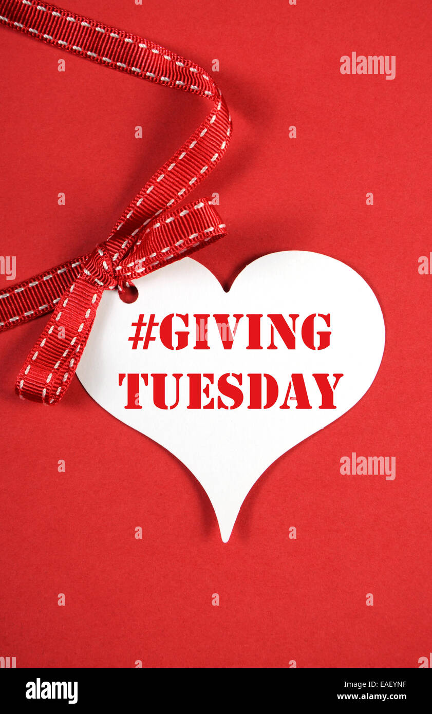 Giving Tuesday philanthropy day after Black Friday shopping message sign with white heart on red background and sample text. Stock Photo