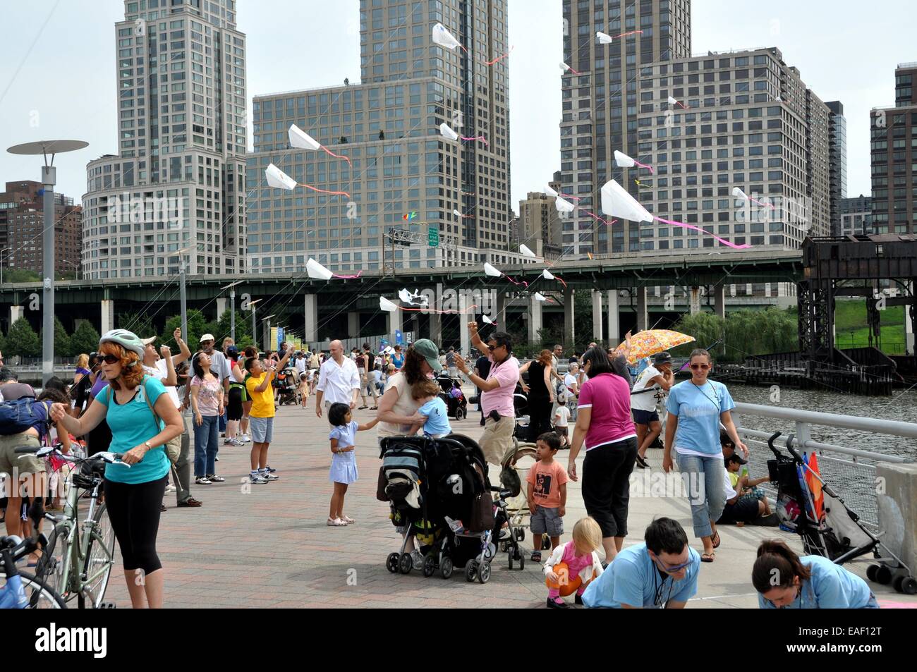 NYC White kites with pink tails fly over Hudson River Pier 70 during the FlyNY Kite Festival
