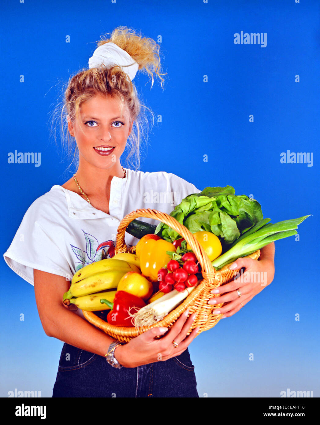 Blond woman with a basket full with fruits and vegetables Stock Photo ...