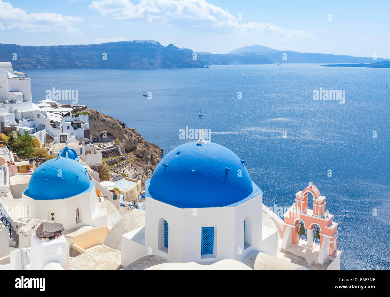 White greek church with blue dome & pink bell tower, Oia, Santorini, Thira, Cyclades Islands, Greek Islands, Greece, EU, Europe Stock Photo