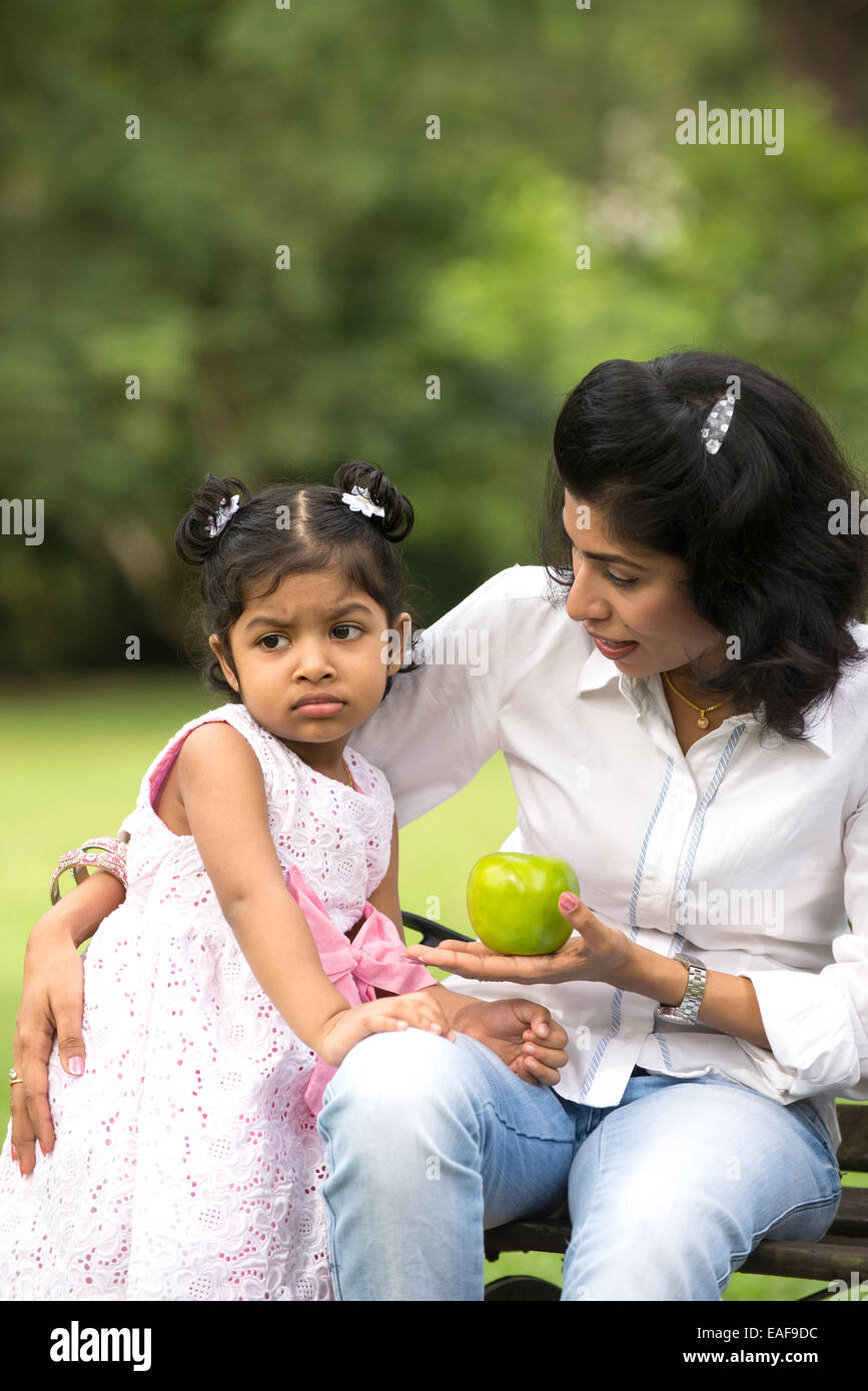 Indian mother and child eating healthy outdoor Stock Photo