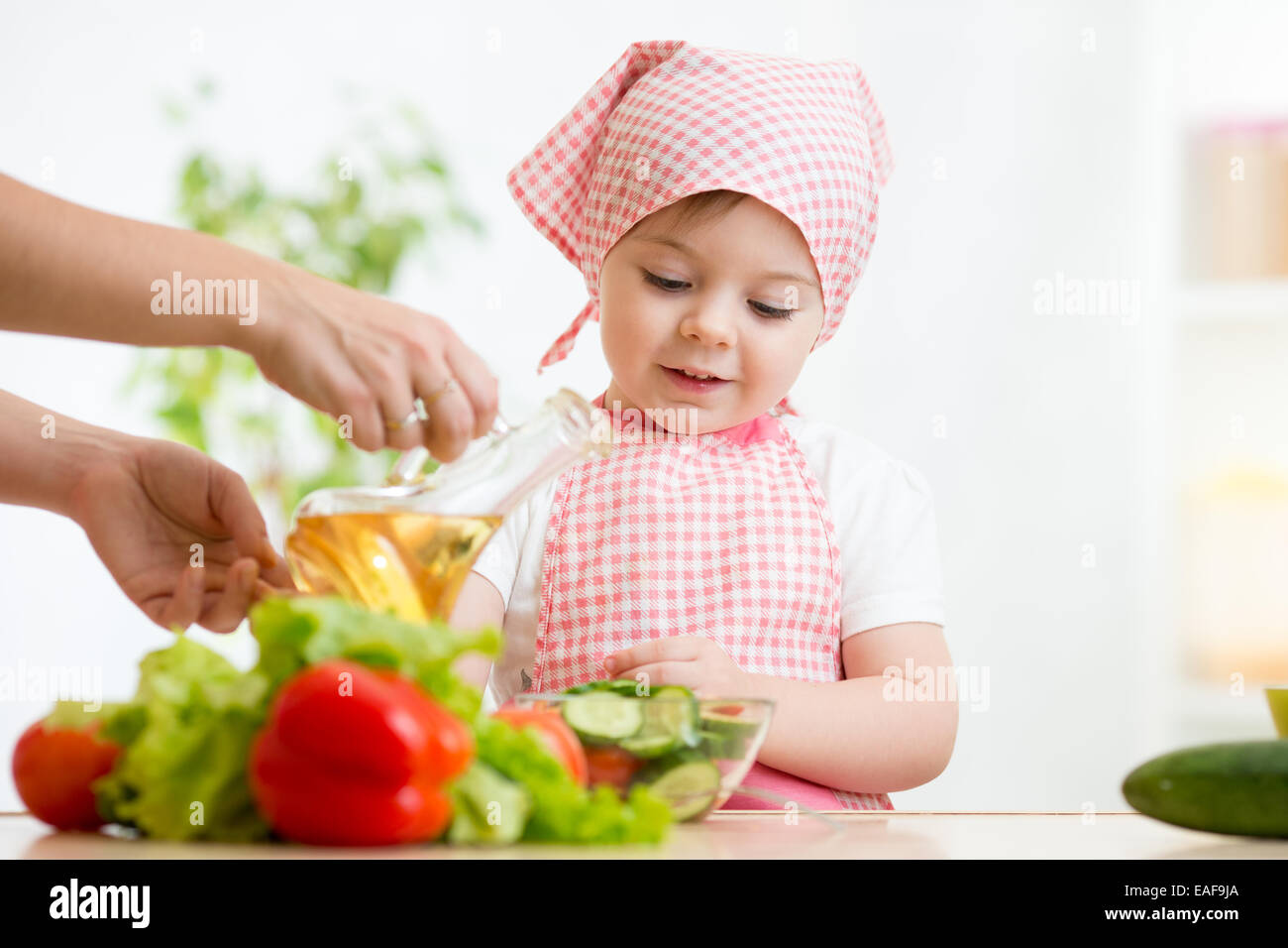little girl with vegetables on kitchen Stock Photo