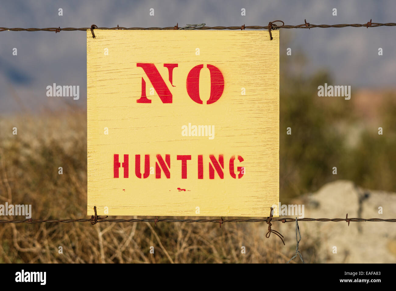 wood no hunting sign wired to a barbed wire fence Stock Photo
