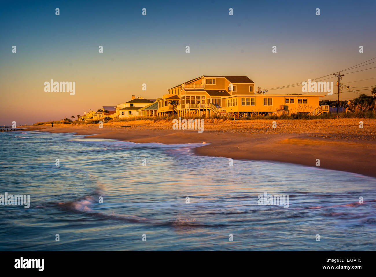Waves in the Atlantic Ocean and morning light on beachfront homes at Edisto Beach, South Carolina. Stock Photo