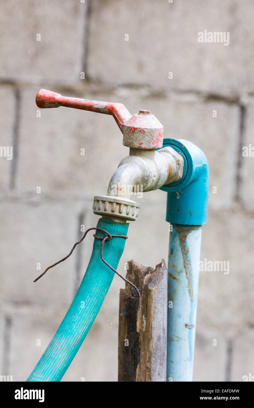 old water tap, PVC pipe and green rubber tube in white background Stock