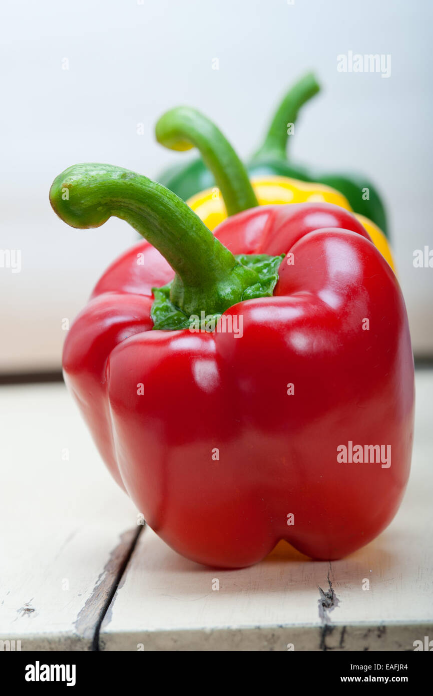 three fresh bell peppers over old wood table Stock Photo - Alamy