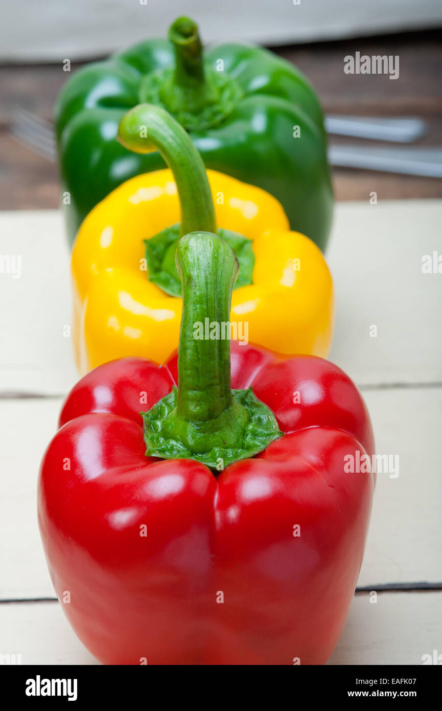three fresh bell peppers over old wood table Stock Photo - Alamy