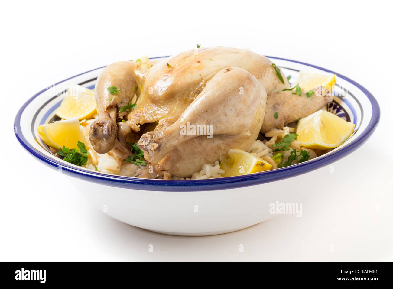 Chicken pilaf, or riz bi djaaj, traditional Arab and Mediterranean boiled chicken and rice dish, served with roasted nuts and le Stock Photo