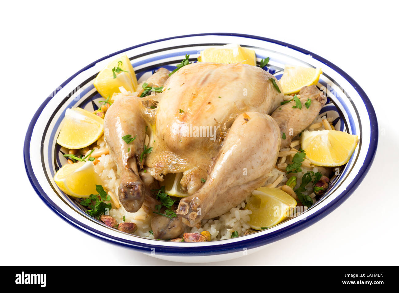 Chicken pilaf, or riz bi djaaj, traditional Arab and Mediterranean boiled chicken and rice dish, served with roasted nuts and le Stock Photo