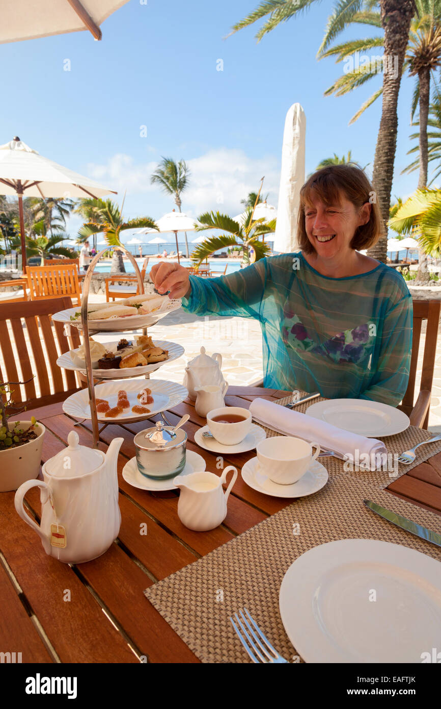 Woman tourist having afternoon tea at the Luxury Residence Hotel, Belle Mare, Mauritius Stock Photo
