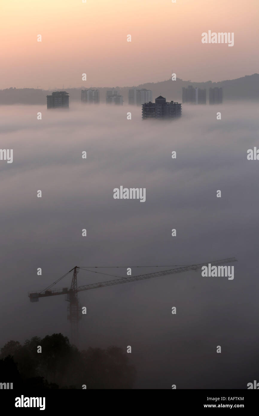 Chongqing. 14th Nov, 2014. A few high-rise buildings penetrate through a stratus cloud that casts over Dazu District of southwest China's Chongqing, early on Nov. 14, 2014. Credit:  Luo Guojia/Xinhua/Alamy Live News Stock Photo