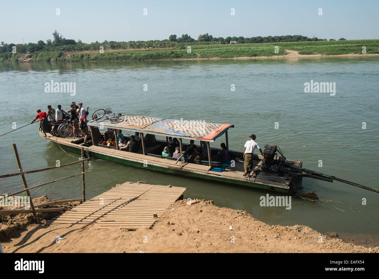River boat taking locals,bikes,and tourists to and from Inwa, Ava area,across Irrawaddy River,near Mandalay,Burma, Myanmar,Asia, Stock Photo