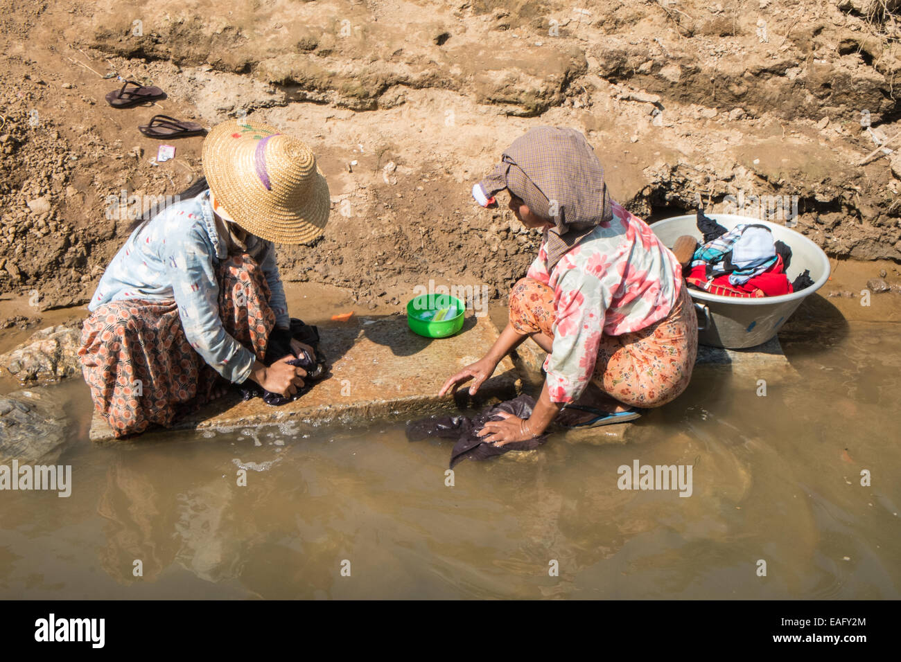 Locals washing clothes, doing laundry, chores on the banks of Irrawaddy River at Inwa,Ava,near Mandalay,Burma,Myanmar,Asia. Stock Photo