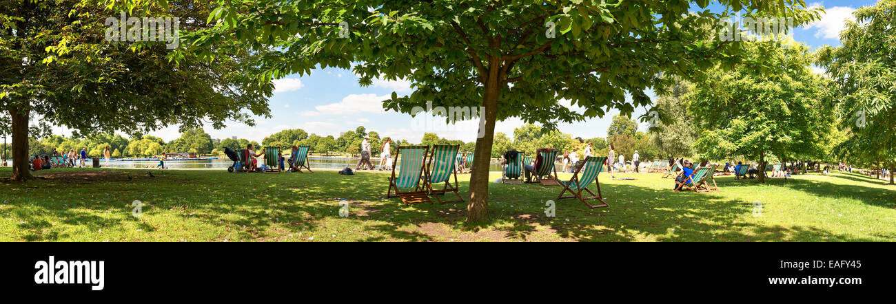Panoramic view of people enjoying the sun by Serpentine Lake in London's Hyde Park Stock Photo