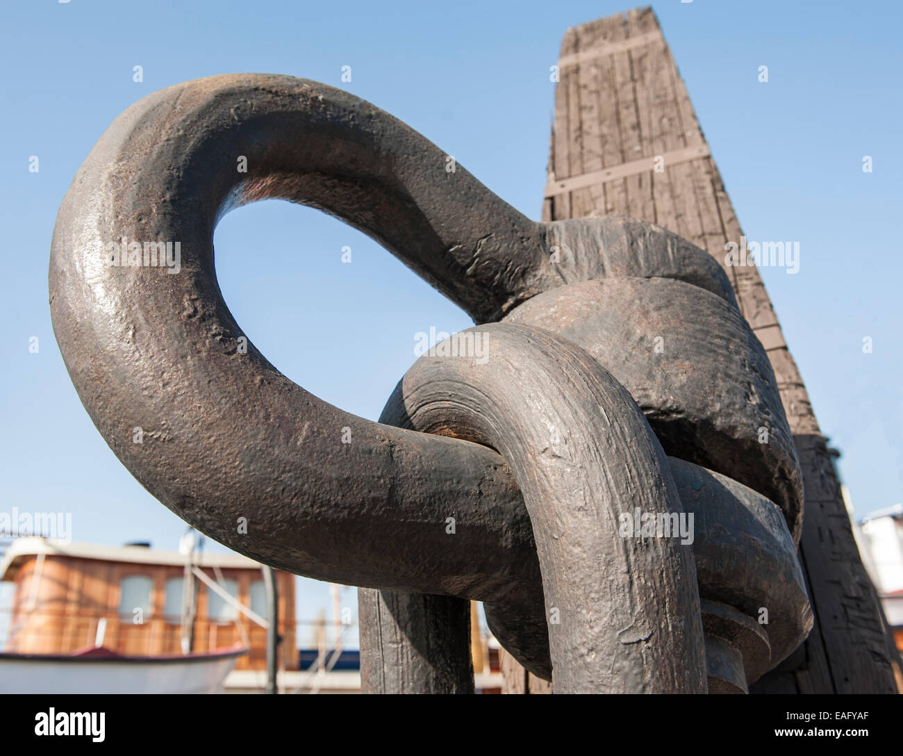 Closeup detail of old marine shackle on rotting wooden mast Stock Photo