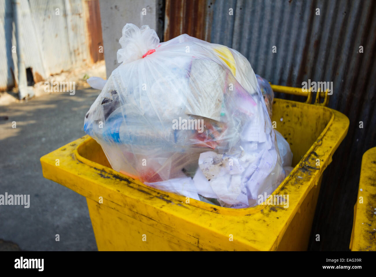 yellow bin full of rubbish in sidewalk in Thailand Stock Photo Alamy