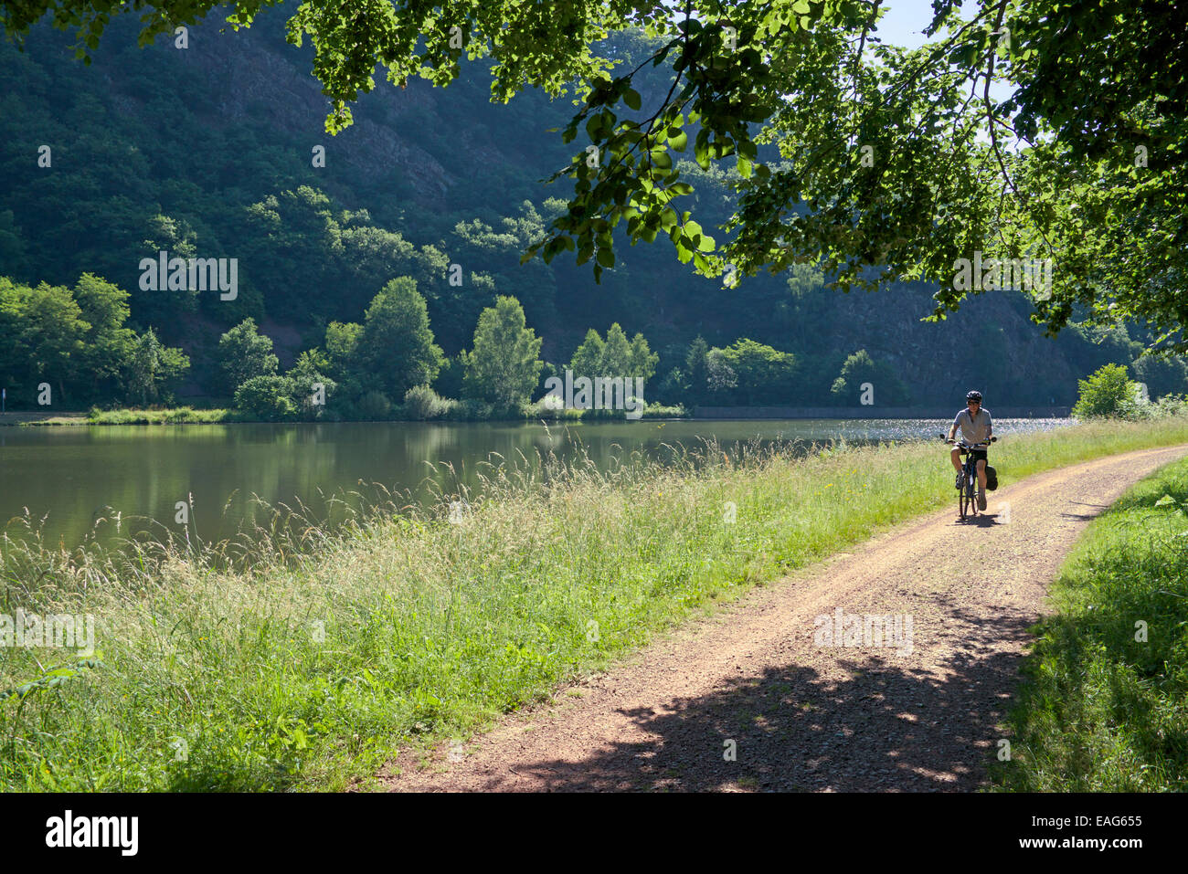 Cyclist on unmade cycle path Upper Saar River Saarland Germany Stock Photo