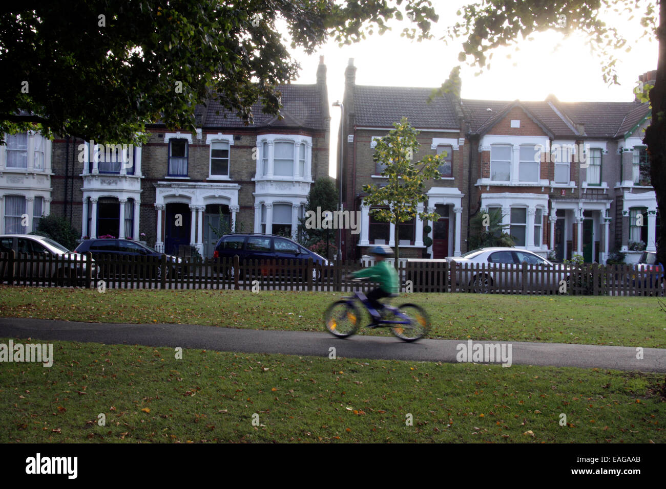 Boy on a bicycle riding through Wanstead Park in East London Stock Photo