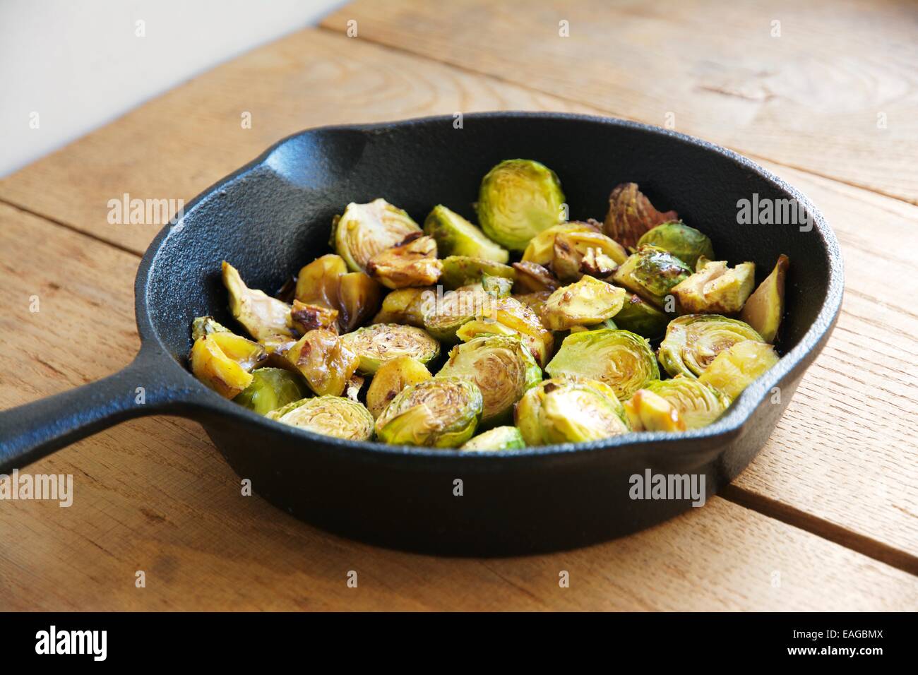 Roasted Brussels sprouts and chestnuts with a balsamic vinegar sauce in a cast iron skillet. Stock Photo
