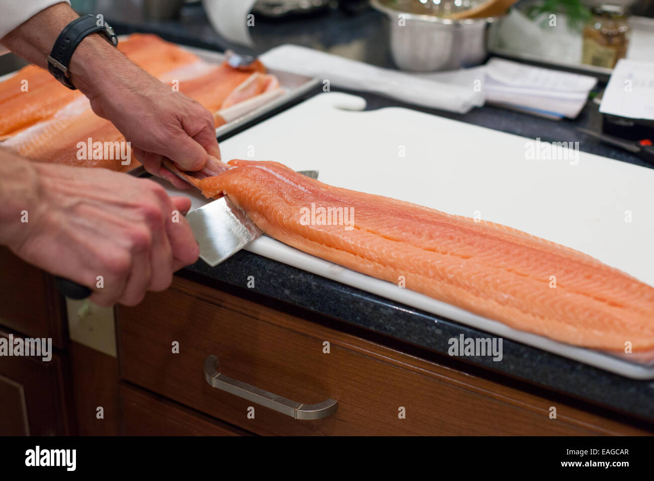 Removing skin from raw salmon fillet Stock Photo - Alamy
